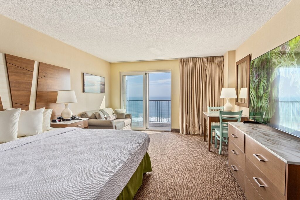 a hotel room with a large bed and ocean view