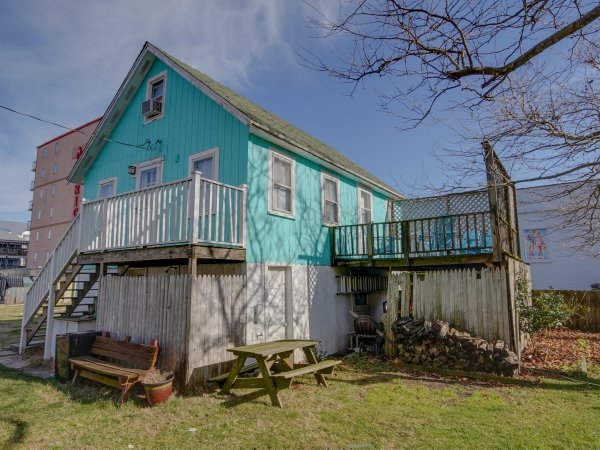 a blue house with a deck and picnic table