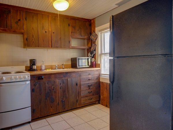 a kitchen with a refrigerator, stove and microwave