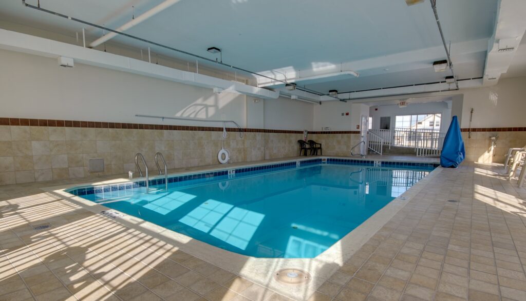 an indoor swimming pool with tiled floors and walls