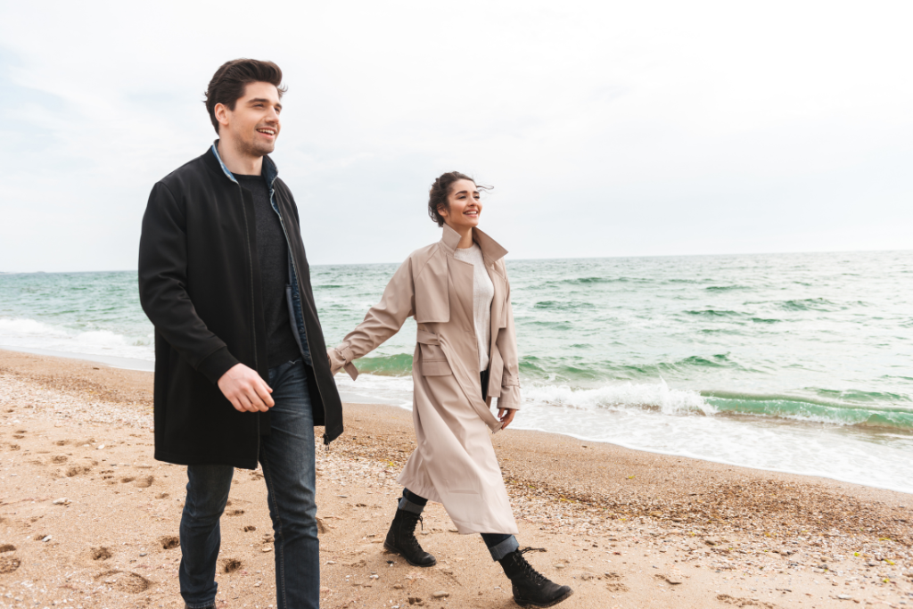 a man and a woman walking on the beach