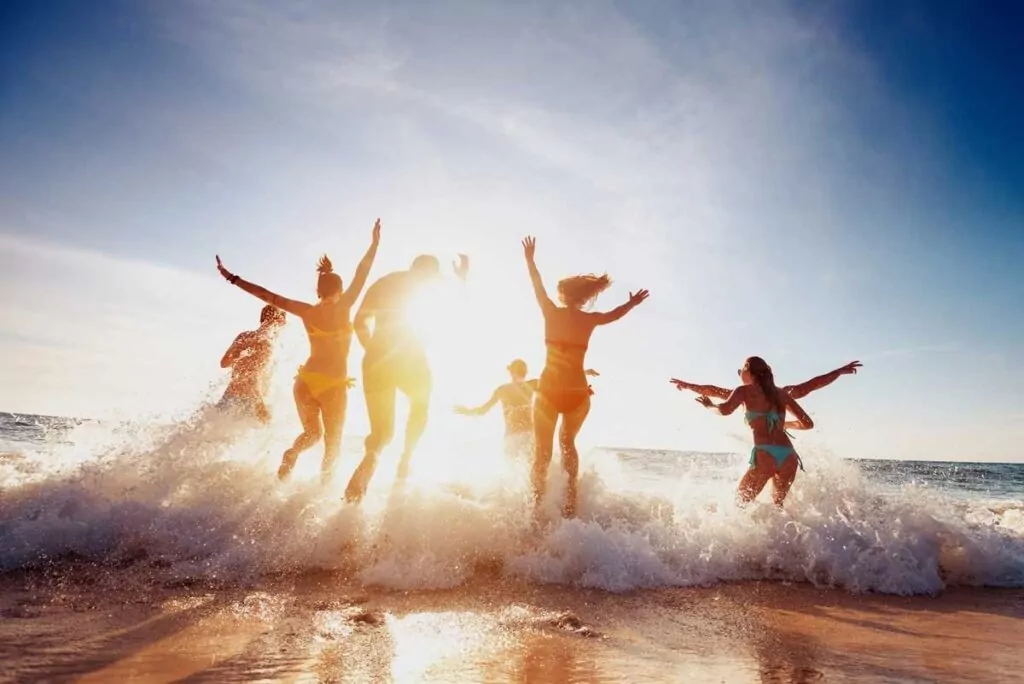 a group of people jumping into the ocean